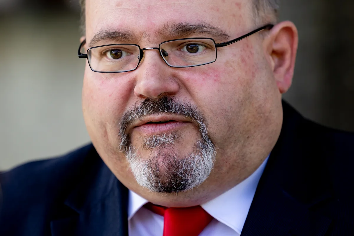 Pascal Bassu, Stadtpräsident von Wetzikon, fungiert als Sprecher des Ausschusses der GZO-Aktionärsgemeinden. (Archiv) Porträt eines Mannes mit Bart und Brille in Grossaufnahme.